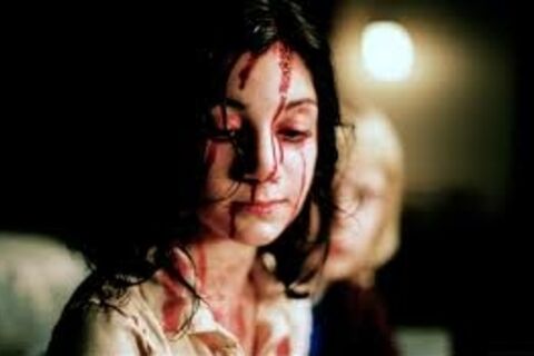 Wiping away the blood from her face.